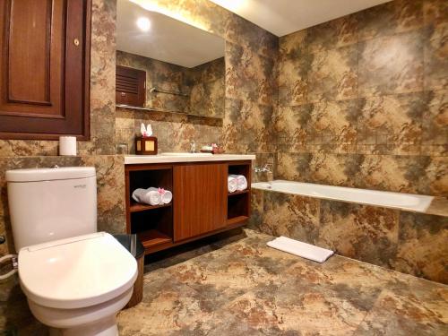 a bathroom with a toilet and a bath tub at Radha Phala Resort & Spa in Ubud