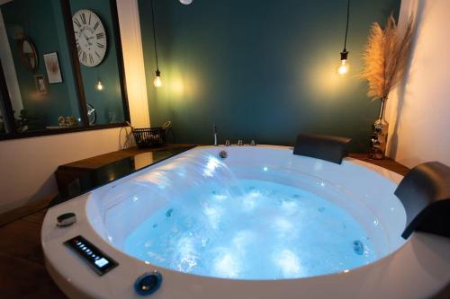 a large bath tub in a room with a clock at Loveappart21 l'expérience Bien Être in Dijon