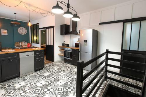 Il comprend une cuisine dotée de carrelage noir et blanc. dans l'établissement Loveappart21 l'expérience Bien Être, à Dijon