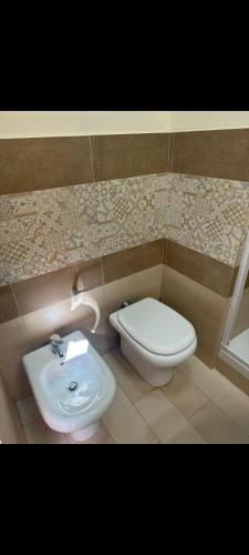 a bathroom with a toilet and a sink at KALGHEROS Luxury Rooms in Agrigento
