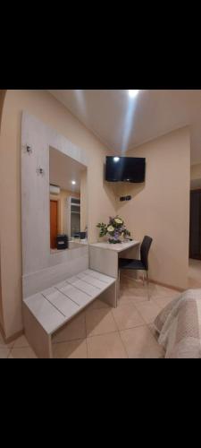 a living room with a desk and a television on the wall at KALGHEROS Luxury Rooms in Agrigento