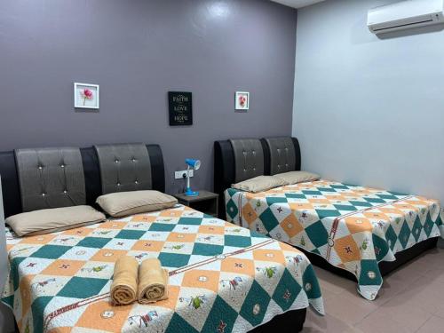 two beds with shoes on them in a room at BOTANI LOFT HOMESTAY in Ipoh