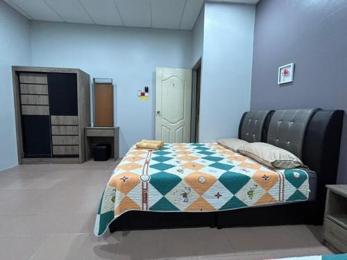ein Schlafzimmer mit einem Bett mit einer Decke darauf in der Unterkunft BOTANI LOFT HOMESTAY in Ipoh