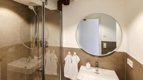a bathroom with a shower and a sink and a mirror at Faust-Appartements 