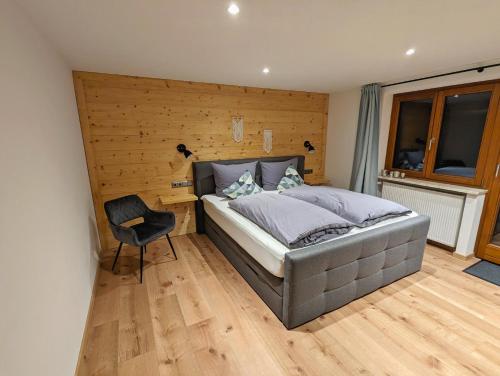 um quarto com uma cama e uma cadeira em Ferienwohnung Stuimändle em Obermaiselstein