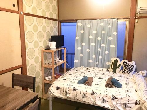 a bedroom with a bed with shoes on it at 10 minutes direct to Shibuya Crossing! Heart of Tokyo! Kamiuma in Tokyo