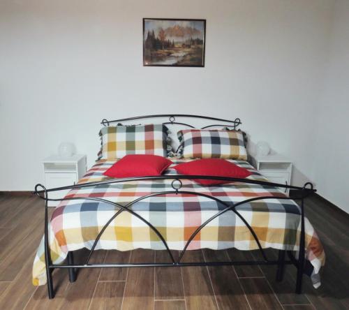 1 dormitorio con 1 cama con almohadas rojas en Il Rifugio delle Rose, en Ronciglione
