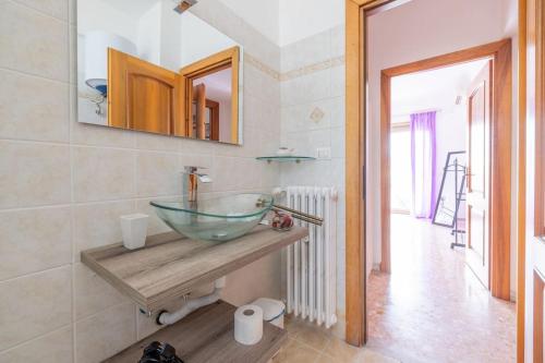 een badkamer met een glazen wastafel op een aanrecht bij Ambra's bright apartment in Rome