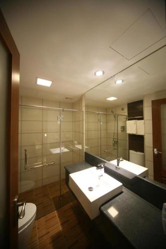 a bathroom with a sink and a toilet and a mirror at Cardogan Hotel in Kuala Lumpur