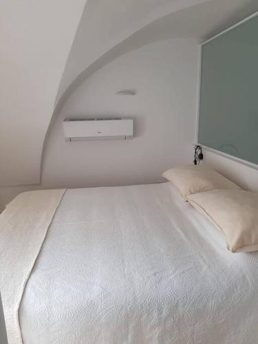 a white bed in a white room with a window at Casa Guido Eco Friendly in Lecce