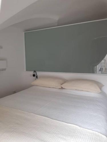 a white bed with two pillows in a bedroom at Casa Guido Eco Friendly in Lecce