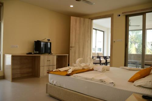 1 dormitorio con 1 cama con toallas en Hotel Dolphin, en Digha