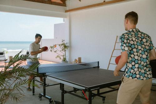 two men standing in a room with a ping pong table at The Nordic House in Bacnotan