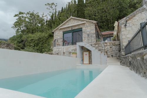a house with a swimming pool next to a building at Casa di Pietra in Kotor