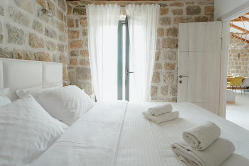 a bedroom with a white bed with towels on it at Casa di Pietra in Kotor