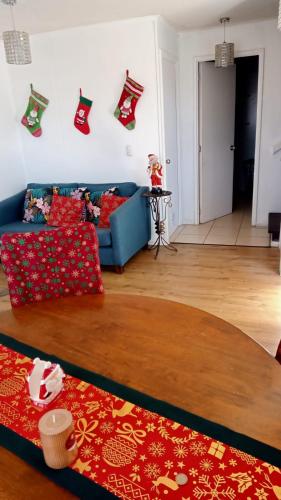 a living room with a blue couch and christmas socks on the wall at Casa Her Pto Montt 3Dorm in Llanquihue