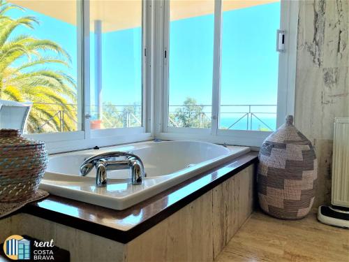 プラヤ・デアロにあるVilla Vistaの大きな窓付きのバスルーム(洗面台付)