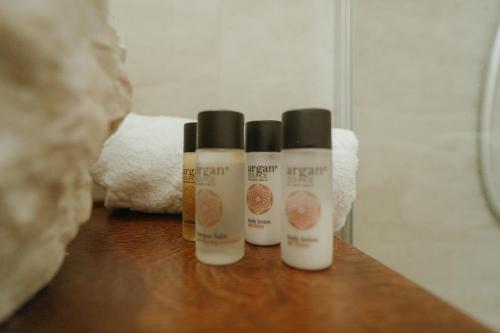 three bottles of hair products sitting on a wooden counter at Casa di Pietra in Kotor