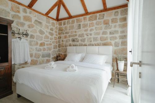 a bedroom with a white bed with towels on it at Casa di Pietra in Kotor