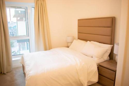 um quarto com uma cama branca e uma janela em Stunning 1-Bed Apartment in London em Hendon