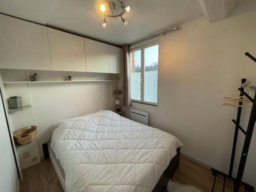 une chambre avec un lit dans une pièce avec une fenêtre dans l'établissement Chez Loulou - Appartement Honfleur -, à Honfleur