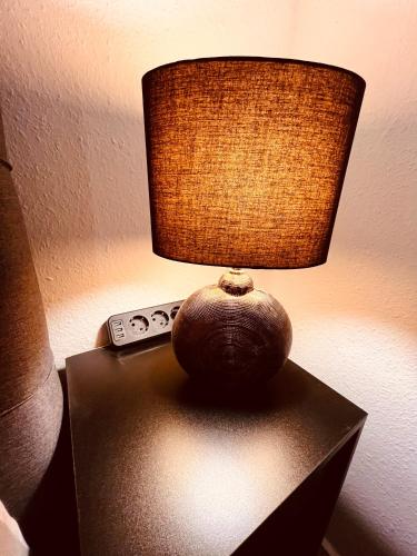 an orange sitting on top of a table with a lamp at Boutique Apartment in Lenzkirch
