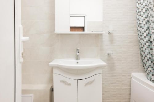 W białej łazience znajduje się umywalka i lustro. w obiekcie Konstanzer Nicolina12 w Jassach