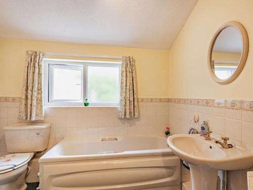 a bathroom with a tub and a toilet and a sink at 3 Bed in Briston 90184 in Briston