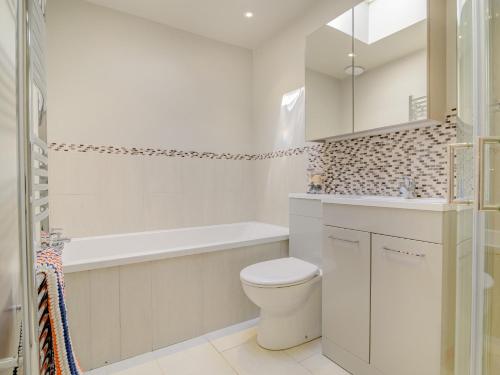 a white bathroom with a toilet and a tub and a sink at 3 Bed in Hay-on-Wye 91642 in Mansel Gamage