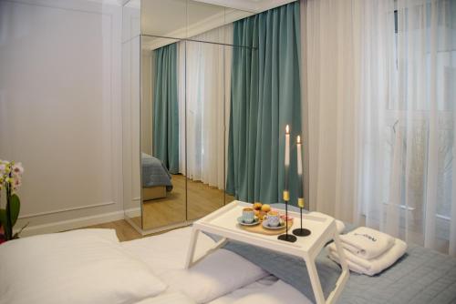 um quarto com uma cama, uma mesa e um espelho em Maya's Flats & Resorts 56 - Szafarnia em Gdansk