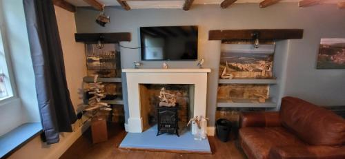 a living room with a fireplace and a couch at Church Street Cottage in Staithes