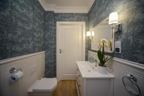 uma casa de banho com um WC, um lavatório e um espelho. em Maya's Flats & Resorts 56 - Szafarnia em Gdansk
