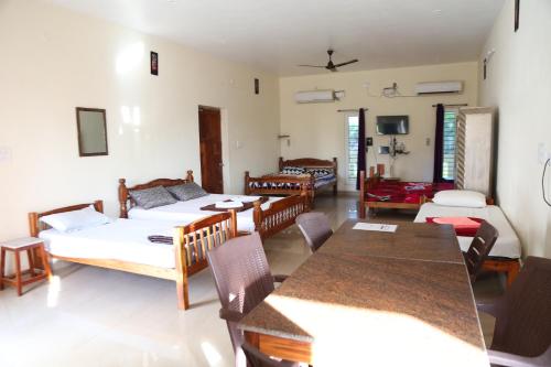 a living room with two beds and a table and chairs at Blissful Haven Art House - near entrance to Auroville in Auroville