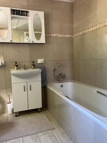 a bathroom with a tub and a sink and a mirror at Time & Again in Ceres