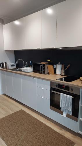 eine Küche mit weißen Schränken und einem Herd in der Unterkunft Apartament Alicja in Międzywodzie