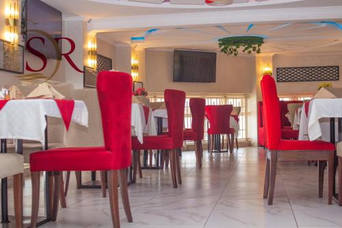 a dining room with red chairs and a table at Selella Resort in Kisumu