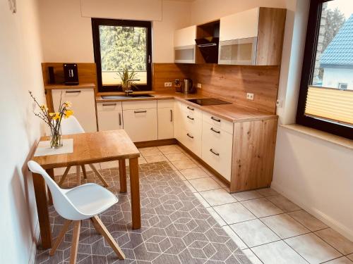 a kitchen with a table and a table and a chair at Stylisches modernes Apartment, Sauna und Wellness Top Lage in Lübbecke