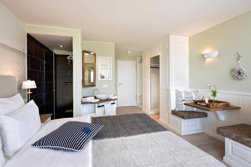 a bedroom with a white bed and a bathroom at Hotel Zweite Heimat in Sankt Peter-Ording
