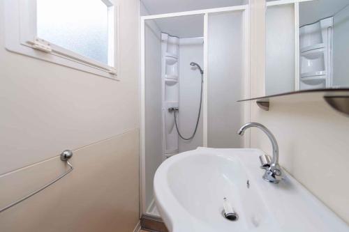 a white bathroom with a shower and a sink at Mobilehomes in Lido di Spina 21308 in Lido di Spina