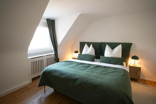 a bedroom with a green bed with a window at Meerjungfrau - W14 in Ulm