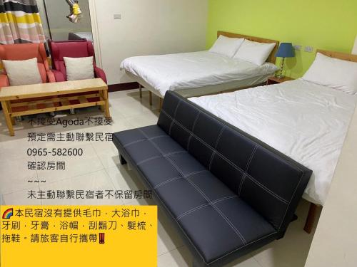 two beds and a bench in a room at Luyu Homestay in Lukang