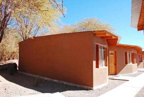 a small brown and white building with a door at Quechua Hotel in San Pedro de Atacama