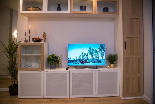 a television on a white entertainment center in a living room at Maya's Flats & Resorts 80 - Garnizon Gdansk in Gdańsk