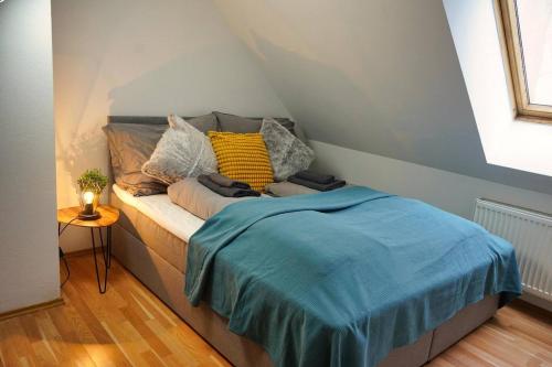 Una cama con una manta azul en una habitación en Beautiful Rooftop Apartment, en Viena