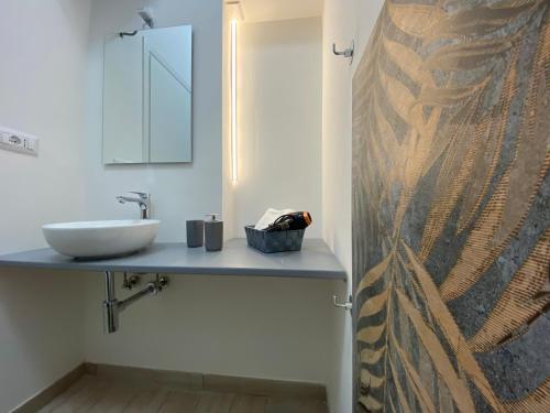 a bathroom with a sink and a mirror at Le casette di Frà Host and Go in Santa Severa