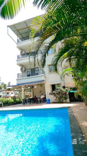 a hotel with a swimming pool in front of a building at Anant Villa & Resorts in Nagaon