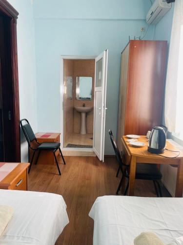 a room with a table and chairs and a bathroom at Villa Jakos Paradise in Batumi