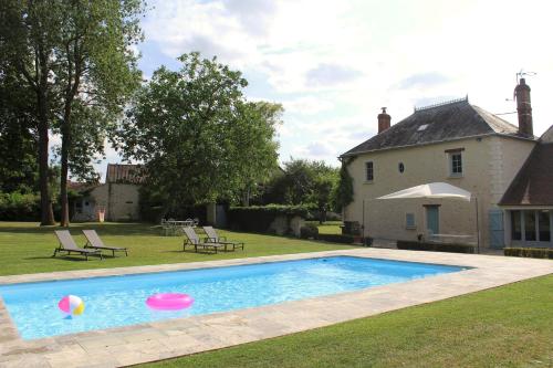 a swimming pool with a frisbee in front of a house at Au bois Noël - LE CHARME in Lescherolles