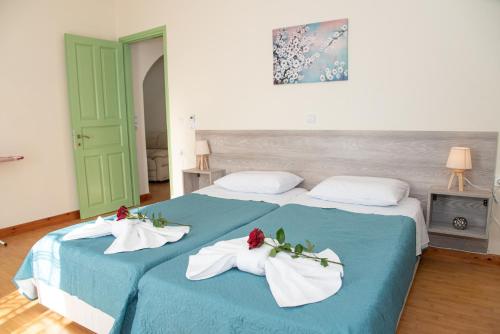 a bedroom with two beds with towels on them at Villa Kouros in Melíssia