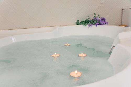 a bath tub with candles in the water at Villa Kouros in Melíssia